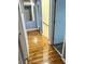 Hallway with wood-look flooring and a mirror detail to give the illusion of more space at 6216 Pangea Ave, Las Vegas, NV 89139