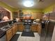 Well-lit kitchen featuring stainless steel appliances, wooden cabinets, and a functional layout at 6216 Pangea Ave, Las Vegas, NV 89139