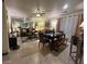 Cozy living room with tile flooring, a ceiling fan, dining table, and a mirrored wall feature at 6216 Pangea Ave, Las Vegas, NV 89139