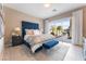 Main bedroom with a blue upholstered bed, sliding doors to the backyard, and a view of the pool at 10325 Jade Point Dr, Las Vegas, NV 89135