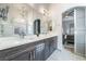 Modern bathroom features a double vanity, large mirror, and glass door shower at 2144 Paganini Ave, Henderson, NV 89052