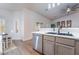 Kitchen featuring a double sink, stainless steel dishwasher, gray cabinets, and a dining area with bright windows at 2144 Paganini Ave, Henderson, NV 89052