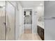 Modern bathroom featuring a walk-in shower with tile surround, a dark wood vanity and a walk-in closet at 2395 Dalewood Ave, North Las Vegas, NV 89086