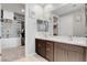 Modern bathroom features double sinks with dark wood cabinets and a walk-in closet with built-in shelving at 2395 Dalewood Ave, North Las Vegas, NV 89086