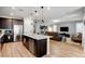 Open kitchen design with wooden cabinetry, large stainless steel refrigerator, and breakfast bar at 2395 Dalewood Ave, North Las Vegas, NV 89086
