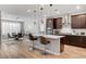 Stylish kitchen island with quartz countertops and seating overlooks a dining area with modern chandelier at 2395 Dalewood Ave, North Las Vegas, NV 89086