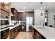 Gourmet kitchen features stainless steel appliances, dark wood cabinets and spacious quartz countertops at 2395 Dalewood Ave, North Las Vegas, NV 89086