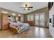 Spacious main bedroom featuring wood flooring, large bed, fireplace, fan, and plenty of natural light at 3906 Jacob Lake Cir, Las Vegas, NV 89118