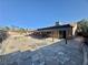 Expansive backyard features stone patio, covered area, mature landscaping, and clear blue sky at 5132 Springland St, Las Vegas, NV 89146