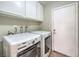 Bright laundry room with washer, dryer, and ample cabinet space at 8608 Alfano Ct, Las Vegas, NV 89117