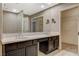 Bathroom featuring dual sinks, a large mirror, walk-in closet, tile flooring, and linen closet at 8805 Litchfield Ave, Las Vegas, NV 89134