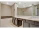 Bathroom featuring dual sinks, a large mirror, walk-in shower, soaking tub, and tile flooring at 8805 Litchfield Ave, Las Vegas, NV 89134