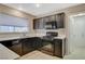 Traditional kitchen featuring dark cabinetry, light countertops, tile flooring, and stainless steel appliances at 8805 Litchfield Ave, Las Vegas, NV 89134