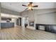 Spacious living room features a fireplace, ceiling fan, and modern vinyl flooring and connects to kitchen at 8805 Litchfield Ave, Las Vegas, NV 89134