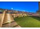 Landscaped backyard with stairs, lighting, and artificial turf at 10185 Sequoia Falls Pl, Las Vegas, NV 89149