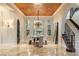 Elegant dining room featuring a chandelier, large windows, and a view of a courtyard fountain at 10308 Rocky Mesa Ct, Las Vegas, NV 89144