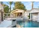 Luxury pool with a bridge, waterfall feature and a covered patio area at 10308 Rocky Mesa Ct, Las Vegas, NV 89144