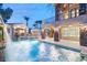 Luxury pool and spa with waterfall feature, at night at 10308 Rocky Mesa Ct, Las Vegas, NV 89144