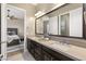 Shared bathroom with double vanity, large mirror, and view into bedroom at 12456 Edinburgh Cask Ave, Las Vegas, NV 89138