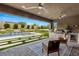 Covered patio features an outdoor kitchen, seating area, and a view of the pool at 12456 Edinburgh Cask Ave, Las Vegas, NV 89138