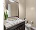 Modern powder room with a white sink, dark vanity, and elegant mirror at 12456 Edinburgh Cask Ave, Las Vegas, NV 89138