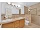 Bathroom with double sinks, shower, and wood cabinets at 1326 Summer Dawn Ave, Henderson, NV 89014