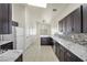 Bright kitchen with dark cabinets, granite counters, and stainless steel appliances at 2005 Ona Marie Ave, North Las Vegas, NV 89032