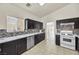 Modern kitchen with dark cabinetry, white appliances, and granite countertops at 2005 Ona Marie Ave, North Las Vegas, NV 89032