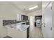 Modern kitchen with dark cabinetry, white appliances, and a breakfast bar at 2005 Ona Marie Ave, North Las Vegas, NV 89032