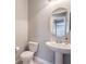 Small powder room with pedestal sink, toilet, and circular mirror at 3267 Royal Fortune Dr, Las Vegas, NV 89141