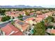 Expansive aerial view of a residential community showcasing homes with red tile roofs and lush green landscaping at 3320 Haven Beach Way, Las Vegas, NV 89117