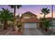 Attractive home with a two-car garage, desert landscaping, and mature palm trees at 3320 Haven Beach Way, Las Vegas, NV 89117
