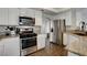 Modern kitchen with white cabinets, granite countertops, and stainless steel appliances at 3320 Haven Beach Way, Las Vegas, NV 89117