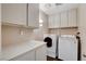 Functional laundry room equipped with a washer, dryer, and storage cabinets at 3320 Haven Beach Way, Las Vegas, NV 89117