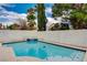 Backyard pool with water feature surrounded by mature trees and desert landscaping at 3320 Haven Beach Way, Las Vegas, NV 89117