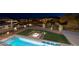 Beautiful backyard view featuring a modern fire pit, desert landscaping, and city lights at twilight at 37 Reflection Shores Ln, Henderson, NV 89011