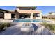 A modern pool and fire pit are part of the backyard featuring a modern home and blue skies in the background at 37 Reflection Shores Ln, Henderson, NV 89011