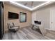 Comfortable office with brick accent wall, modern desk, tv and sleek grey swivel chair at 37 Reflection Shores Ln, Henderson, NV 89011