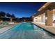Backyard view of pool at dusk with fire feature, covered patio, and nearby landscaping at 37 Reflection Shores Ln, Henderson, NV 89011