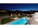 Inviting backyard featuring a modern pool, spa, fire pit, and covered outdoor dining space at twilight at 37 Reflection Shores Ln, Henderson, NV 89011
