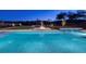 Beautiful pool area with a waterfall feature and an outdoor fire pit at twilight at 37 Reflection Shores Ln, Henderson, NV 89011
