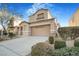 Two-story house with tan exterior, landscaping, and a two-car garage at 3817 Bella Legato Ave, North Las Vegas, NV 89081