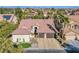 Single-story home with a tile roof, two-car garage, and landscaped yard; city views in background at 5378 Pendini Point Ct, Las Vegas, NV 89141