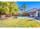 Inviting backyard oasis featuring a sparkling pool, lush landscaping, and relaxing patio space at 5378 Pendini Point Ct, Las Vegas, NV 89141