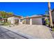 Three-car garage with paver driveway and desert landscaping at 5378 Pendini Point Ct, Las Vegas, NV 89141