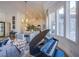 Living room features a modern piano and bay windows overlooking the backyard at 5378 Pendini Point Ct, Las Vegas, NV 89141