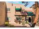 Tan two-story stucco townhouse with green awning and tile roof at 6750 Del Rey Ave # 122, Las Vegas, NV 89146