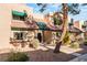 Tan stucco townhouse with green accents and mature tree in front at 6750 Del Rey Ave # 122, Las Vegas, NV 89146