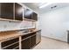 Kitchen boasts dark brown cabinets, granite countertops, and a double sink at 6750 Del Rey Ave # 122, Las Vegas, NV 89146