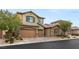 Two story house with tan siding, brown garage doors and stone accents at 7563 Saguaro Cactus Ave, Las Vegas, NV 89178